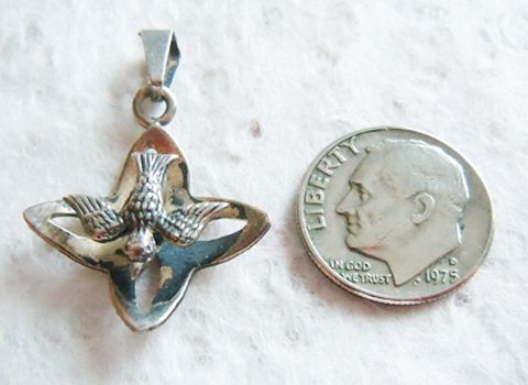   of this religious charm pendant it s the descending dove flying above